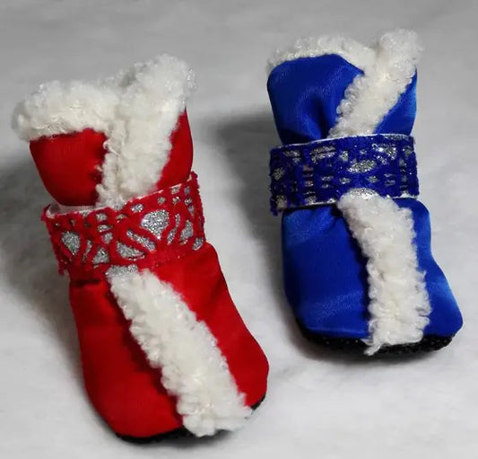 Red and blue dog boots with white fur lining on a gray background