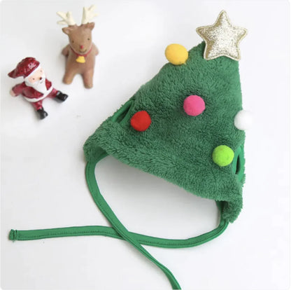Green plush Christmas tree pet hat with colorful pom-poms and a star on a white background.